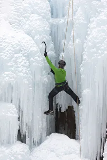 USA, Colorado, Uncompahgre National Forest. Climber ascends ice-encrusted cliff face