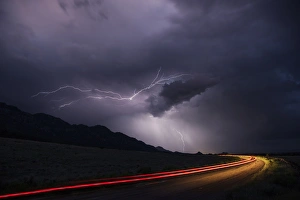 Streak Prints: USA, Colorado, Upper Arkansas River Valley. Lightning stormover vehicle light track
