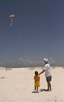 USA; Florida; Young boy learning to fly a kite on the beach at Pensacola. (MR)