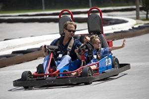 Father Prints: USA; Georgia; Savannah; Father and son riding a go kart. (MR)