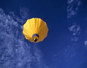 Soar Prints: USA, Idaho, Teton Valley. A brilliant yellow hot-air balloon hovers over Teton Valley