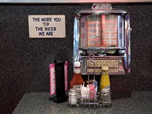 Player Prints: USA, Illinois, Chicago. Old-time tableside jukebox and humorous sign at a nostalgic diner