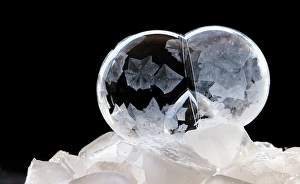 Images Dated 23rd January 2024: USA, Indiana, Carmel. Frozen soap bubbles with feather-like crystals on bed of ice