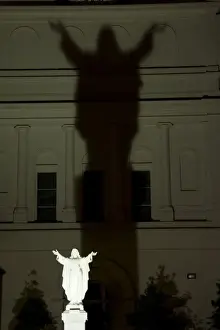 French Quarter Prints: USA, Louisiana, New Orleans. Night scene of illuminated statue of Christ casting