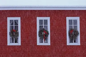 School House Prints: USA, Michigan, Three Christmas wreathes in schoolhouse windows during snowfall. Credit as