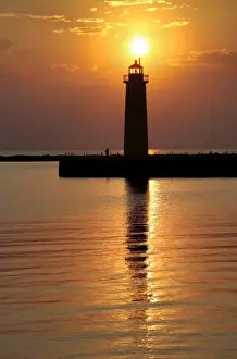 Fisherman Prints: USA, Michigan, Muskegon. The setting sun silhouettes the lighthouse on Lake Michigan in Muskegon