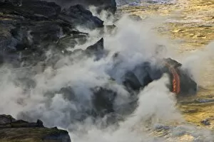 USA. Molten lava flows into the ocean at sunrise in Volcanoes NP on the Big Island of Hawaii