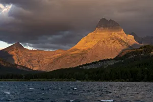 Images Dated 16th January 2022: USA, Montana, Glacier National Park. Stormy sunrise on Mt Wilbur and lake