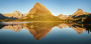 Images Dated 21st March 2023: USA, Montana, Glacier National Park. Sunrise panoramic of lake and mountain