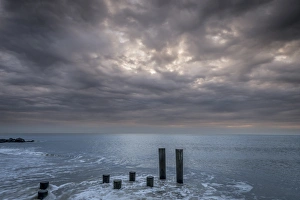 New Jersey Prints: USA, New Jersey, Cape May National Seashore. Beach pilings on stormy sunrise. Credit as