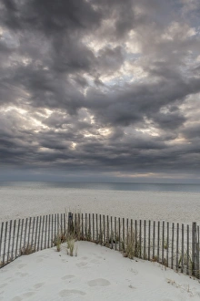 New Jersey Prints: USA, New Jersey, Cape May National Seashore. Beach fence and stormy sunrise. Credit as