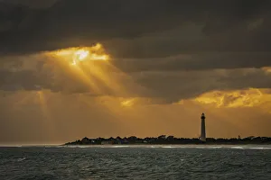 USA, New Jersey, Cape May National Seashore. Sunset on ocean shore and lighthouse