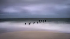 Images Dated 29th April 2021: USA, New Jersey, Cape May National Seashore. Jetty supports and wave spry on beach