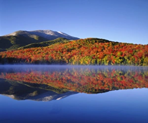 Reflecting Prints: USA; New York; Snow Capped Algonquin Peak and autumn colors relecting in Heart Lake