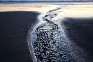 Low Tide Prints: USA, Oregon, Bandon. Water flows into ocean at low tide on Bandon Beach. Credit as
