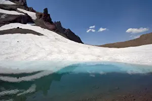 Tarn Prints: USA, Oregon, Broken Top. A snow field reflects into a glacial tarn near Broken Top