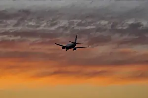 Images Dated 14th June 2008: USA, Oregon, Portland. Airplane with landing gear down making a final approach to land at sunset