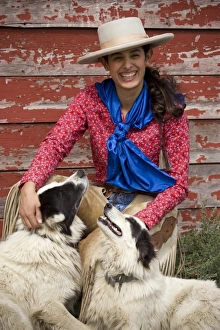 USA, Oregon, Seneca, Ponderosa Ranch. Portrait of a smiling cowgirl and her two dogs