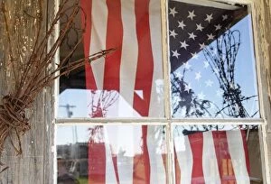 Images Dated 24th June 2004: USA, Oregon, Shaniko. Flag in window next to coil of barbed wire. Credit as: Nancy