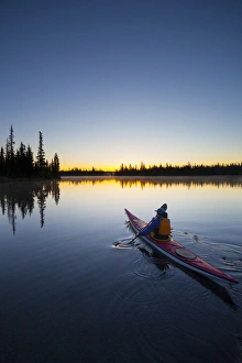 Images Dated 5th July 2011: USA, Oregon. A woman in a sea kayak paddles at dawn on Big Lake, Oregon, in the Oregon