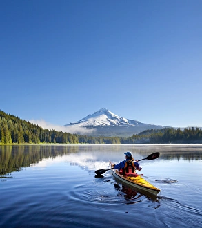 Sea Kayak Prints: USA, Oregon. A woman in a sea kayak paddles on Trillium Lake