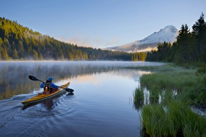 USA, Oregon. A woman in a sea kayak paddles on Trillium Lake, Oregon, in the Oregon Cascades