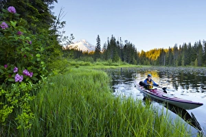 USA, Oregon. A woman in a sea kayak paddles on Trillium Lake, Oregon, in the Oregon Cascades