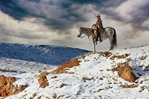 Images Dated 9th June 2022: USA, Shell, Wyoming. Hideout Ranch cowgirl on horseback riding on ridgeline snow. (PR, MR)