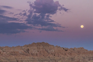 USA, South Dakota, Badlands National Park. Sunrise and moonset over rugged landscape