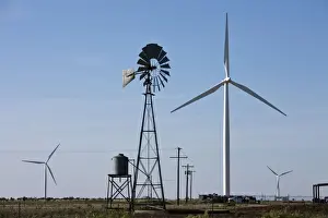 Modern Prints: USA, Texas, Vega, Old ranch windmill and water pump beneath array of wind power generating