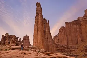 Exercise Prints: USA, Utah. Hiker watches sunset on Fisher Towers sandstone formations