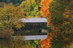 USA, Vermont. Covered bridge and autumn reflections