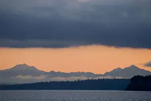 Ominous Prints: USA, WA, Puget Sound. Cascade Mountains predawn with dense deck of storm clouds above