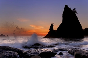USA, Washington, Olympic National Park. Sunset silhouettes and splashing waves on Rialto Beach