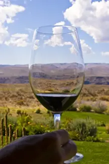 Red Wine Prints: USA, Washington, Quincy. A sample of red wine in a glass overlooking Cave B Inn and Winery grounds