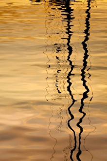 USA, Washington, San Juan Islands. Sailboat mast reflection at sunset. Credit as