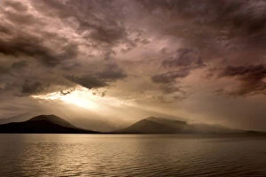 USA, Washington, Seabeck. God rays shine through dark clouds over Hood Canal. Credit as