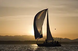 Images Dated 7th May 2007: USA, Washington, Seattle, Setting sun lights yacht sailing in Elliot Bay on spring