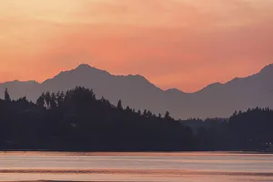 Seattle Prints: USA, Washington State. Olympic Mountains silhouetted in dramatic light. Calm Puget Sound
