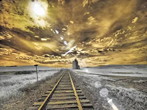 USA, Washington State, Palouse. Backcountry rail Road and Silo through wheat field with