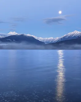 Images Dated 4th October 2021: USA, Washington State, Seabeck. Moon setting over the Olympic Mountains and Hood Canal