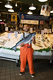 USA, Washington State, Seattle. Fish merchant with large Chinook or King salmon