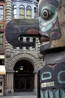 USA, Washington State, Seattle. Totem pole with Pioneer building in Pioneer Square
