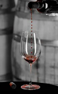 USA, Washington State, Woodinville. Red wine pouring into is captured in mid-air before USA, Washington State, Woodinville. Red wine pouring into is captured in mid-air before