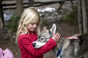 Images Dated 25th September 2007: USA. Wyoming. Grand Tetons National Park. Young girl pets Husky puppy. (MR)
