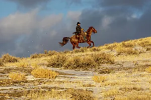 Images Dated 2nd December 2022: USA, Wyoming. Hideout Horse Ranch, wrangler on horseback in snow. (MR, PR)