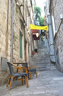 View from the Prijeko street up a narrow street with steep stairs. Two rattan chairs