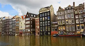 View of the unique architecture and gabled homes and coffee shop along a colorful canal