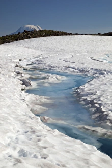 WA, Goat Rocks Wilderness, Melt water on snow and ice covered Goat Lake, with top