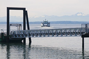 Washington State ferry arriving at terminal in downtown Seattle. Olympic Mountains Washington State ferry arriving at terminal in downtown Seattle. Olympic Mountains